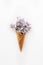 Card with Close up Bouquet of spring purple lilac flowers in the waffle cone on the white background. Top view. Flat lay. Space fo