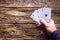 Card player holds four aces on a wooden background with space for text