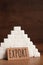 Card with word Export near pyramid of sugar cubes on wooden table, space for text