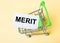 The card with the word MERIT is in the shopping cart. Marketing concept