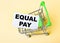 The card with the words EQUAL PAY is in the shopping cart. Marketing concept