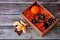 Cardboard box with chocolate and tangerine pieces on a wooden table