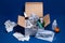 Cardboard box with medical supplies on dark blue background. Cold and flu season