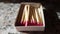 Cardboard box with pink matches on a grey granite table