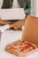 Cardboard box with tasty italian pizza for businessman work from home