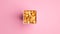 Cardboard box with tasty popcorn on pink background top view