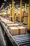 Cardboard Boxed Packages on a Belt Driven Line Roller Conveyor in a Warehouse With Shiny New Line Rollers, E-Commerce Fulfillment