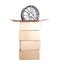 Cardboard boxes on a white background from which a modern automotive alloy disc sticks out. The concept of buying alloy wheels for