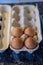 Cardboard carton with four brown hens eggs