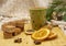 Cardboard disposable Christmas glass with a drink and various sweets and aromatic spices on a wooden tray .