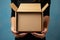 Cardboard embrace Female hands cradle an open empty brown box