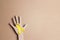 Cardboard hand silhouette with yellow awareness ribbon and copy space on cardboard background