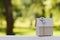 Cardboard house with key against green bokeh. Building, loan, housewarming, insurance, real estate or buying new home.