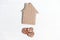 Cardboard house and wooden hearts with inscriptions Love on white background. Overhead view