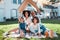 Cardboard roof, portrait and family relax on the lawn of new home, property or real estate, happy and excited. House