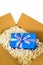 Cardboard shipping box, blue surprise gift inside, polystyrene packing pieces, vertical