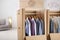Cardboard wardrobe boxes with clothes on hangers in room