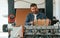 Cardboards in hands. Handsome man is working at the factory of creating eco boxes