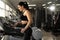 Cardio workout. Side view of happy athletic woman in young sportswear adjusting speed on treadmill while exercising in