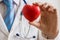 Cardiologist doctor holds red heart in hand