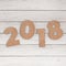 Cardstock Numbers 2018 Happy New Year Sign over table. 3d Render