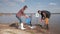 Care nature ecology, family volunteers with little son cleaning up plastic and polyethylene trash on dirty waterfront