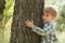 Care for nature - little boy embrace tree