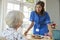 Care nurse serving dinner to a senior woman at home