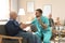 Care worker examining elderly patient with stethoscope in hospice