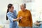 Care worker helping elderly woman to walk in hospice