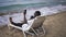 Carefree African American man taking selfie on smartphone lying on sunbed with azure blue waves splashing on sandy beach