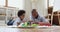 Carefree African dad and son talking playing wooden cubes set