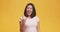 Carefree asian woman demonstrating rock and roll hand gesture, punk sign, orange studio background