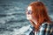 Carefree beautiful red hair young woman over seascape