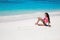 Carefree bikini model girl with heart on sand relaxing on exotic