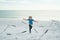 Carefree child. Kid runs along the coast and chases the birds. Seagull fly away. Boy and seagull on the beach, excited