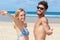 carefree couple with open arms on deserted beach