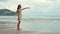 Carefree girl looking to horizon at beach. Teenager pointing to sky at seaside.