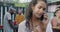 Carefree girl student dancing at street party and talking on mobile phone holding beer bottle