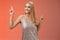Carefree good-looking stylish glamour blond young 20s woman in silver glittering dress dancing having fun amused go wild