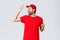 Carefree handsome bearded guy, delivery employee in red t-shirt and cap, singing with closed eyes, raising finger up as