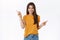 Carefree, happy smiling girl in yellow t-shirt shopping with confident relaxed expression, pointing sideways left and