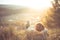 Carefree happy woman lying on green grass meadow on top of mountain edge cliff enjoying sun on her face. Enjoying nature sunset