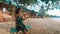 Carefree happy woman on swing on beautiful paradises beach