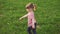 Carefree little girl dancing on grass in park