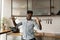 Carefree lively African guy dancing alone in domestic kitchen