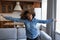 Carefree lively African teenage girl having fun dancing alone indoors