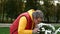 Carefree mature adult man in bright clothing with pleasure sniffing fragrant flowers in the park. Close-up.