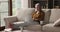 Carefree older woman relaxing on sofa with computer