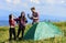 Carefree relax. hiking outdoor adventure. man and two girls pitch tent. wanderlust discovery. mountain tourism camp